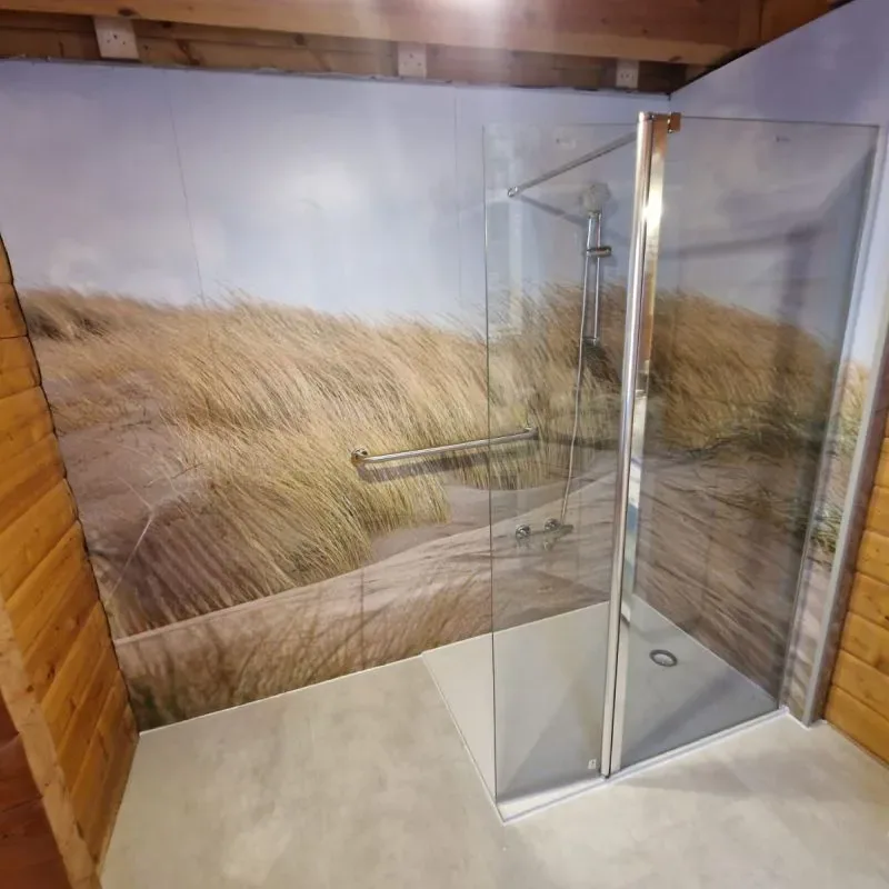 Dusche mit fugenlosem Wanddekor in Dünenoptik und Glastrennwand
