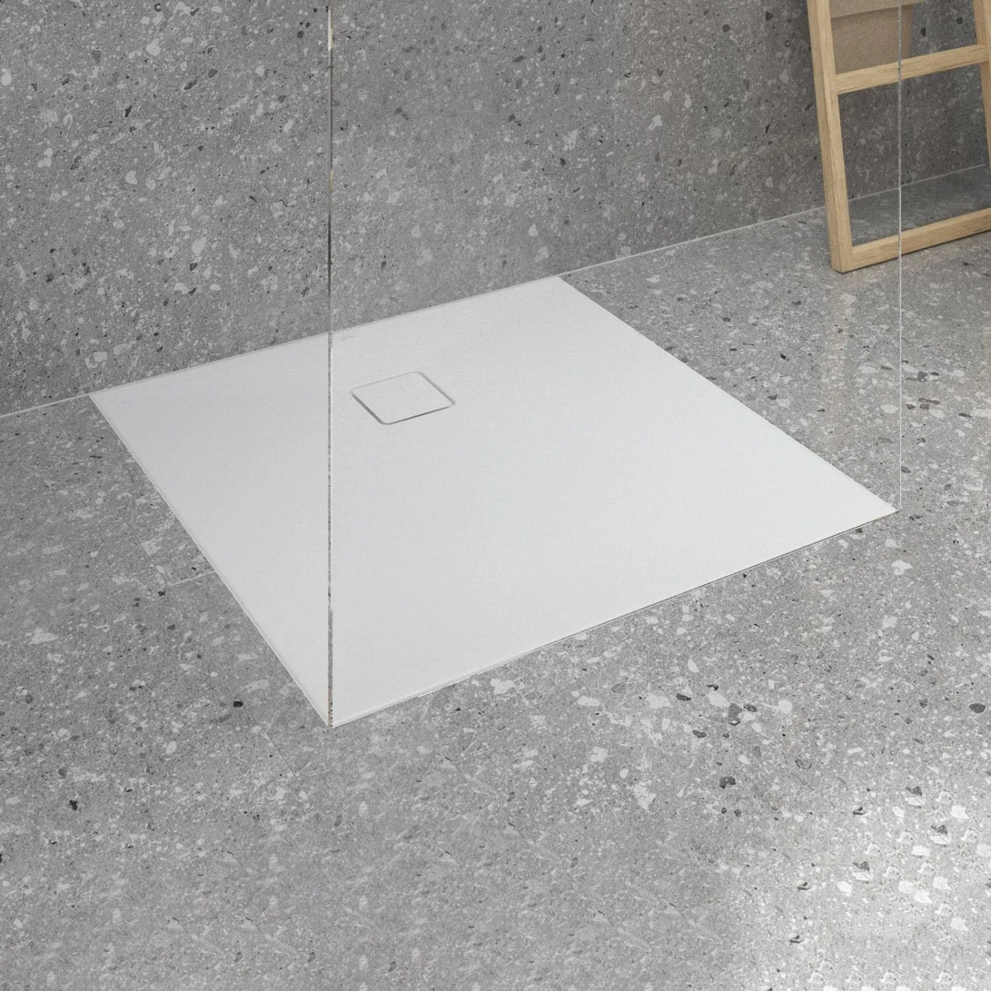 Quadratische weiße Duschwanne mit flacher Ablaufabdeckung in einem Bad in Terrazzooptik